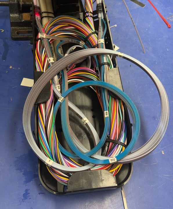 Splice closure before repair, with tangled fiber slack and disorganized routing
