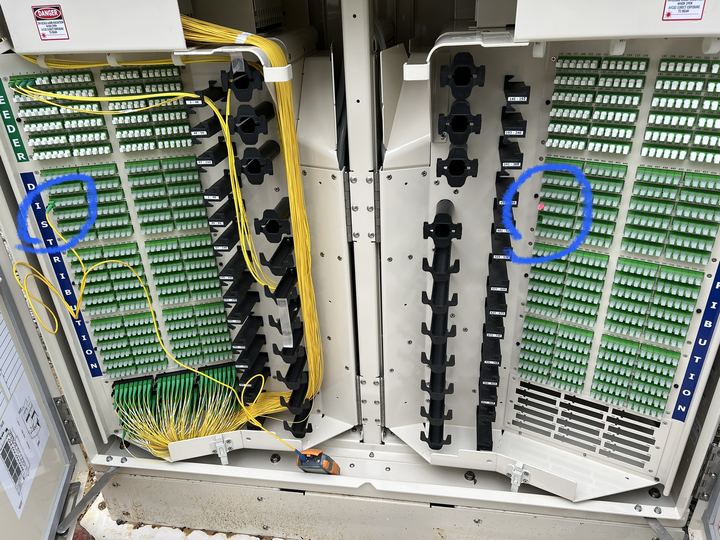 Fiber distribution cabinet with two ports circled in blue, port 1 and port 433