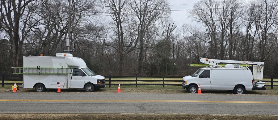 Splice truck and bucket truck parked roadside with traffic cones